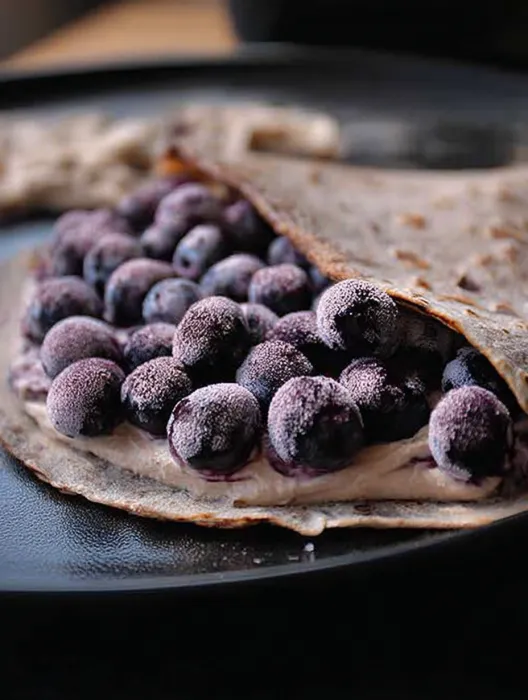 A blueberry pancake with blueberries on top.