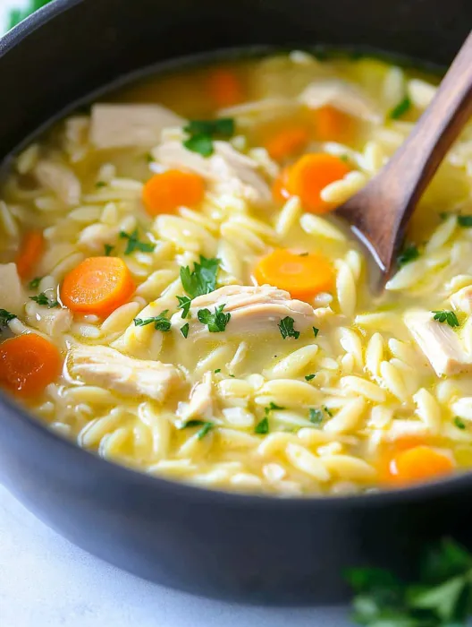 A bowl of soup with carrots and rice.