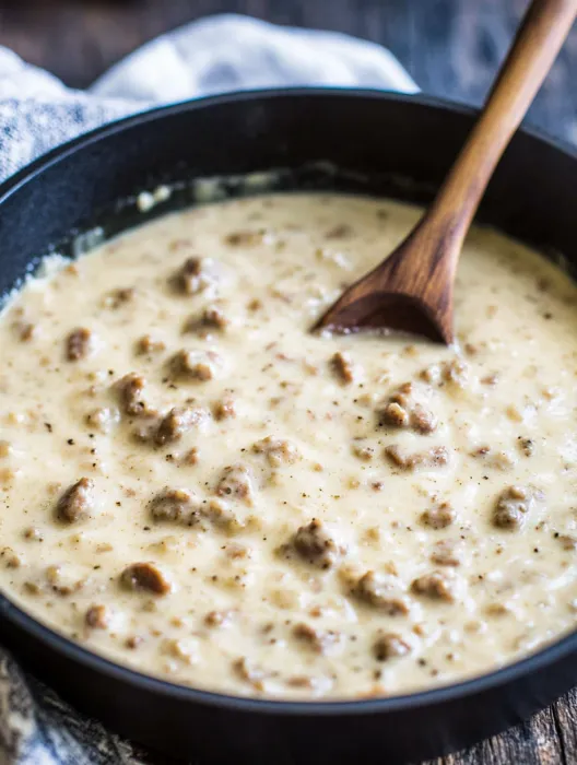 A wooden spoon in a bowl of soup.