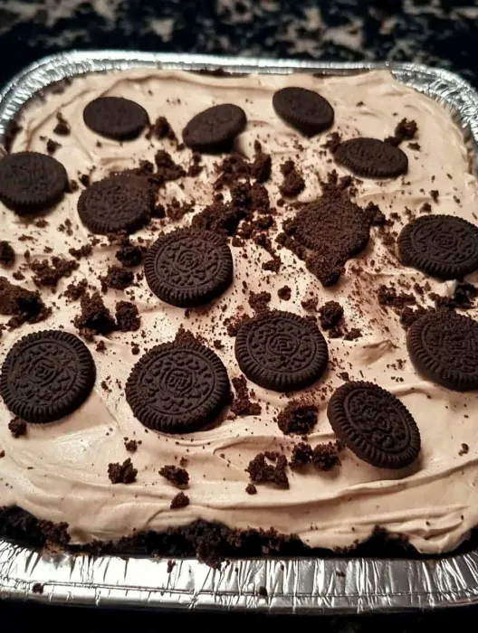 A close up of a chocolate cake with Oreo cookies on top.