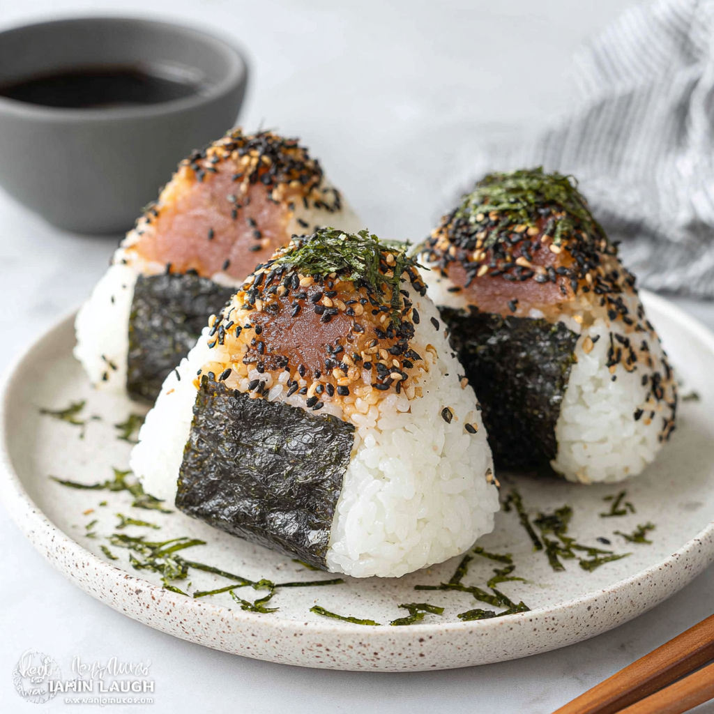 Three pieces of Japanese tuna onigiri on a plate.