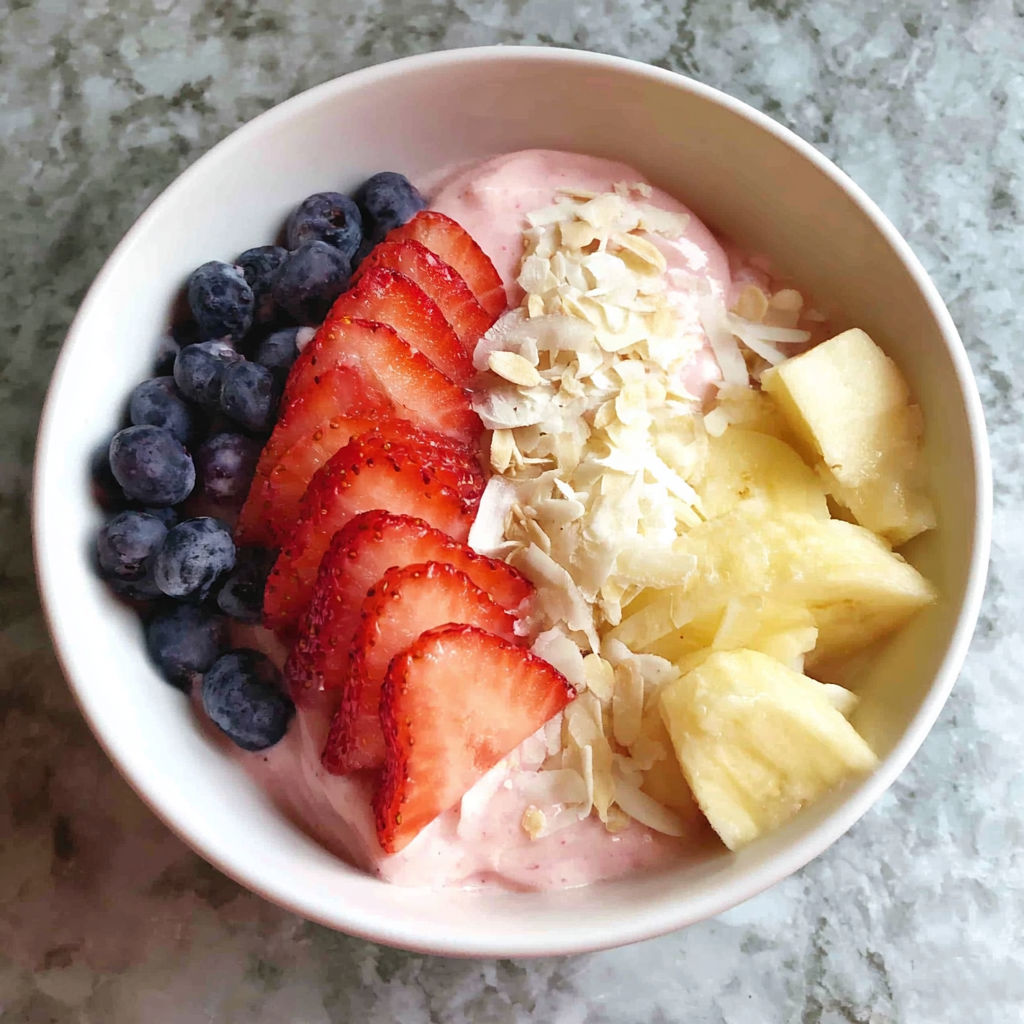 A bowl of fruit with strawberries, blueberries, and yogurt.