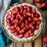 A pie with strawberries and whipped cream.