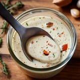 A spoon in a jar of soup.