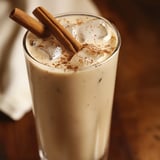 A glass of horchata with cinnamon sticks in it.