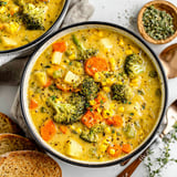 A bowl of soup with broccoli and carrots.