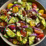A bowl of zesty Mediterranean avocado salad.