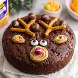 A chocolate cake with orange and chocolate candies on top.