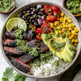 A bowl of food with meat, tomatoes, corn, and avocado.