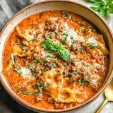 A bowl of pasta with sauce and cheese.