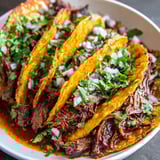 A plate of meat and onions in a crock pot.
