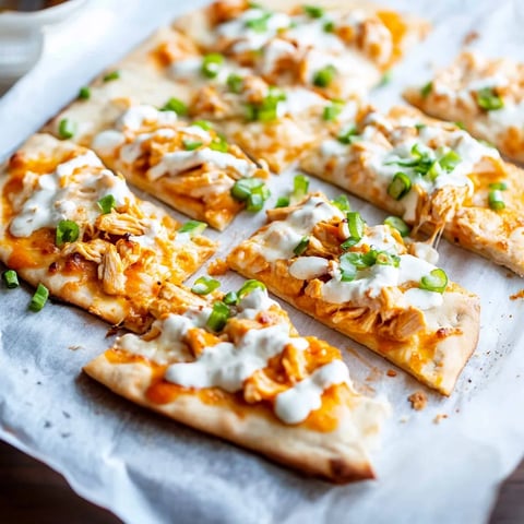 A pizza with chicken and cheese on a white plate.