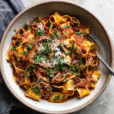 A bowl of pasta with meat sauce.
