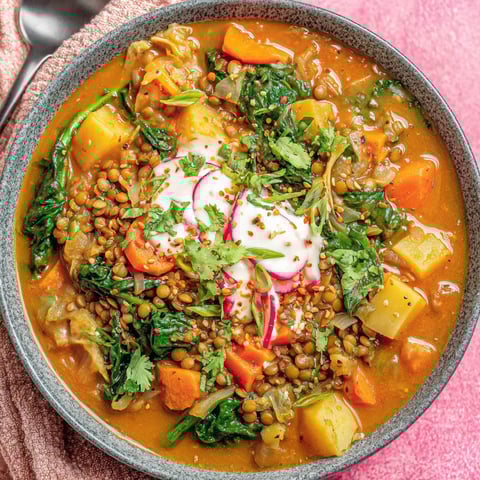 A bowl of soup with vegetables and lentils.