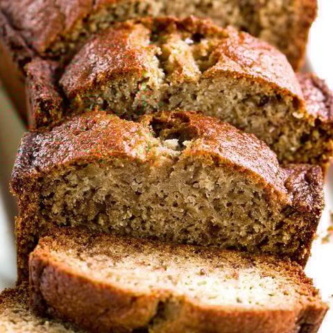 A loaf of banana bread with a slice missing.