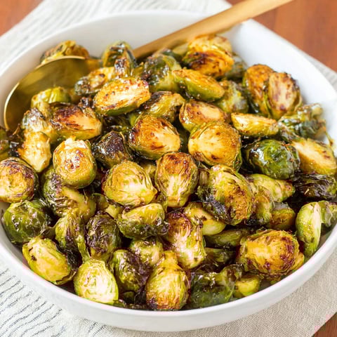 A white bowl filled with Brussels sprouts.