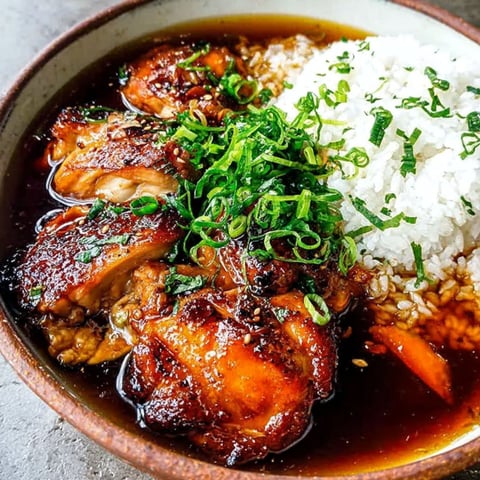 A bowl of food with rice and chicken.