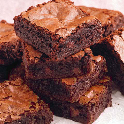A stack of brownies on a plate.